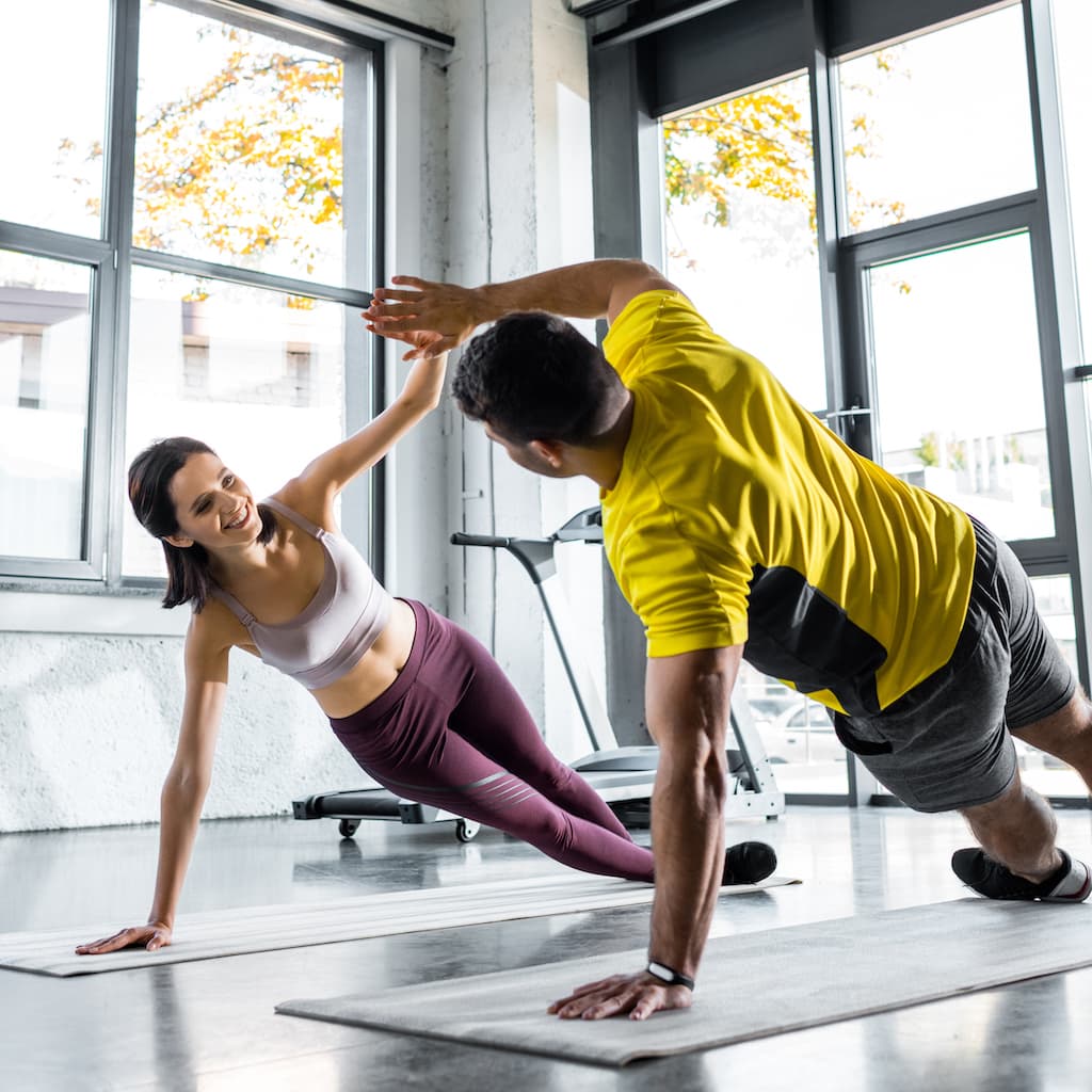 Coach and trainee in a plank hold together.